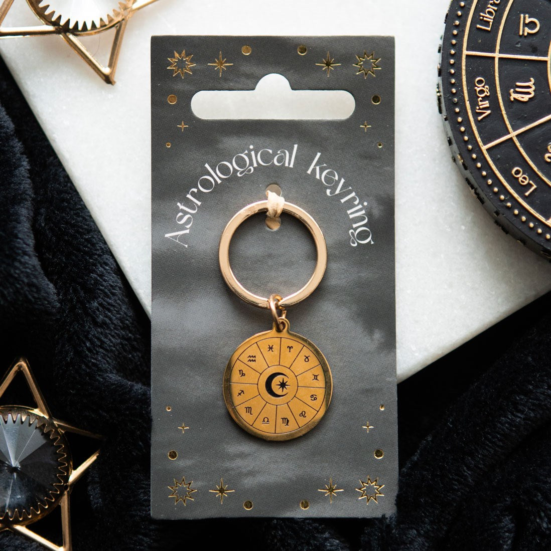 Astrology wheel keyring lifestyle shot on backing card with gold star decorations