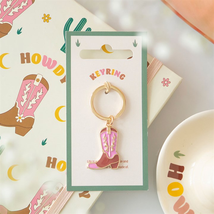 Pink cowboy boot keyring lifestyle shot on Howdy backing card with Western wrapping paper and bowl