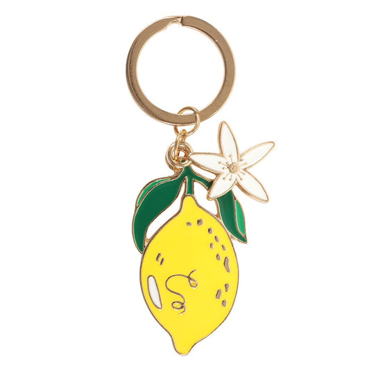 Lemon flower enamel keyring charm close up on white background showing yellow lemon with green leaves and white blossom