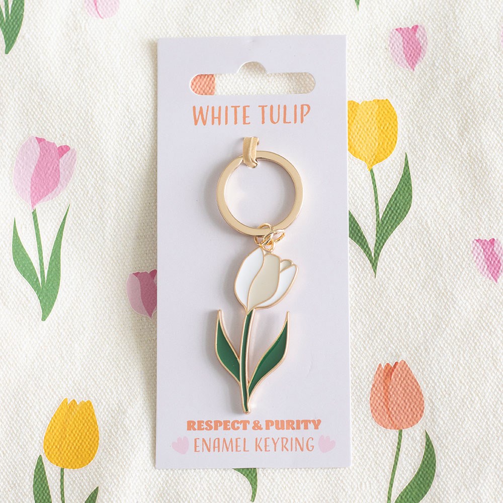 White Tulip enamel keyring lifestyle shot on pink backing card with tulip print background