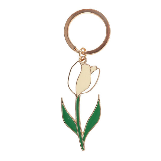 White tulip enamel keyring charm close up on white background showing green leaves and gold detailing