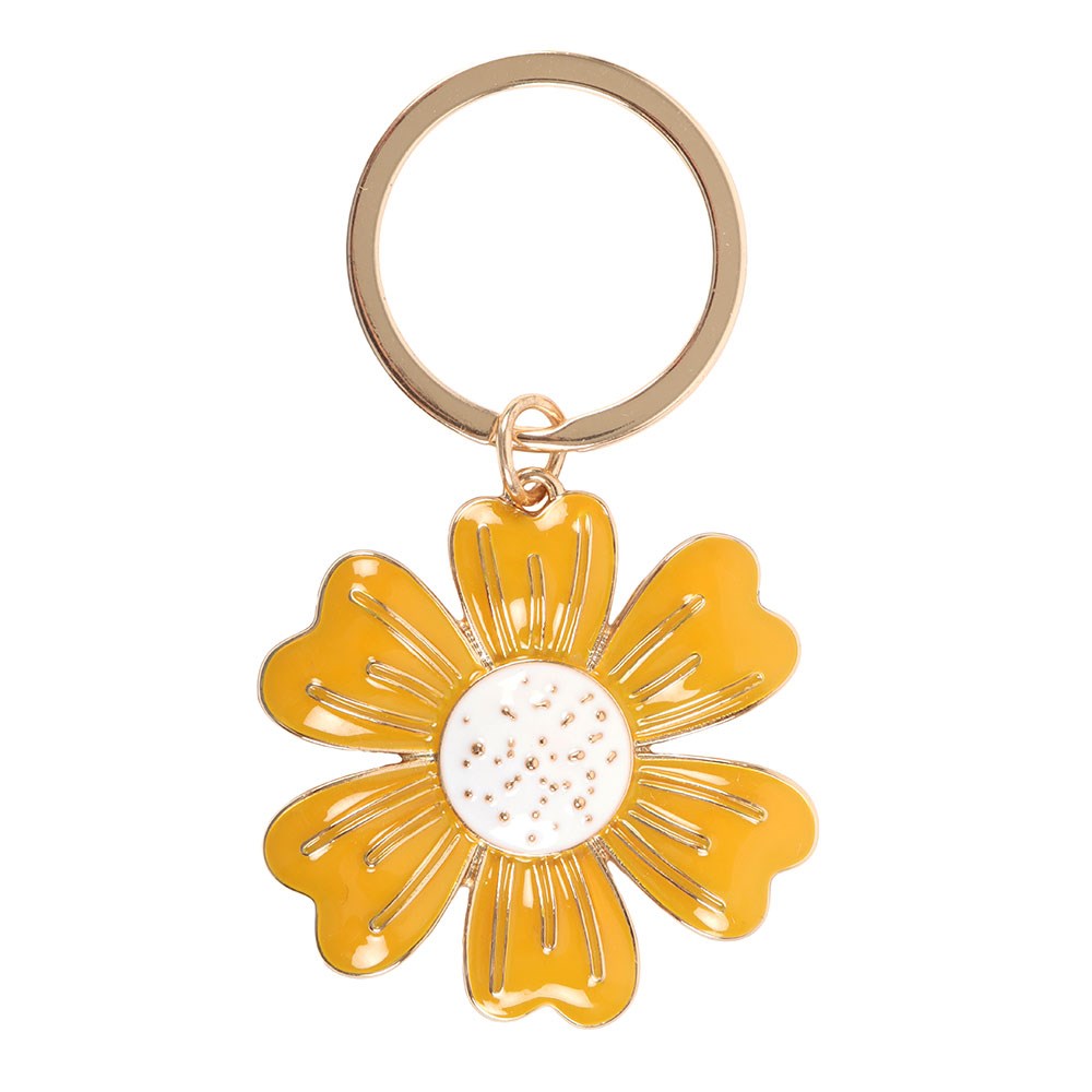 Yellow daisy flower keyring charm close up on white background showing gold petal detailing and white enamel centre