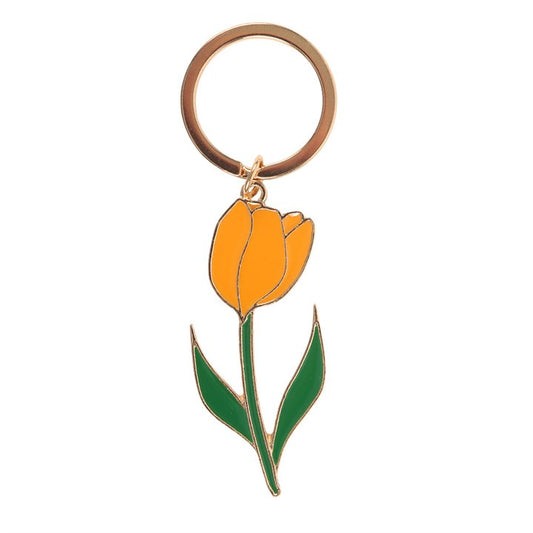 Yellow tulip enamel keyring charm close up on white background showing green leaves and gold detailing
